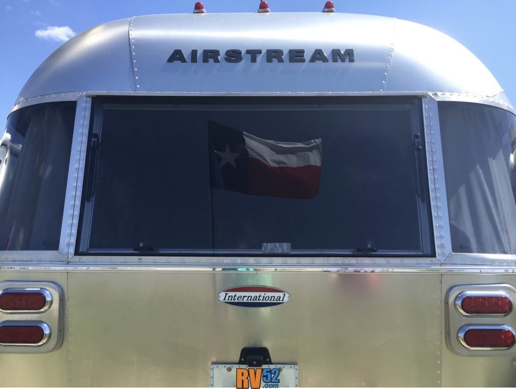 Texas Flag framed in the back window of an Airstream Travel Trailer.